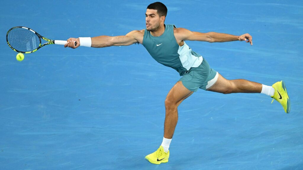 a man in shorts and a T-shirt with a tennis racket in his hands tries to hit the ball